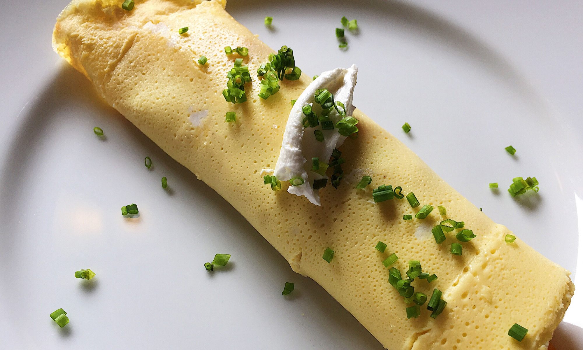 Close-up of a chef preparing a french omelette on a frying pan in