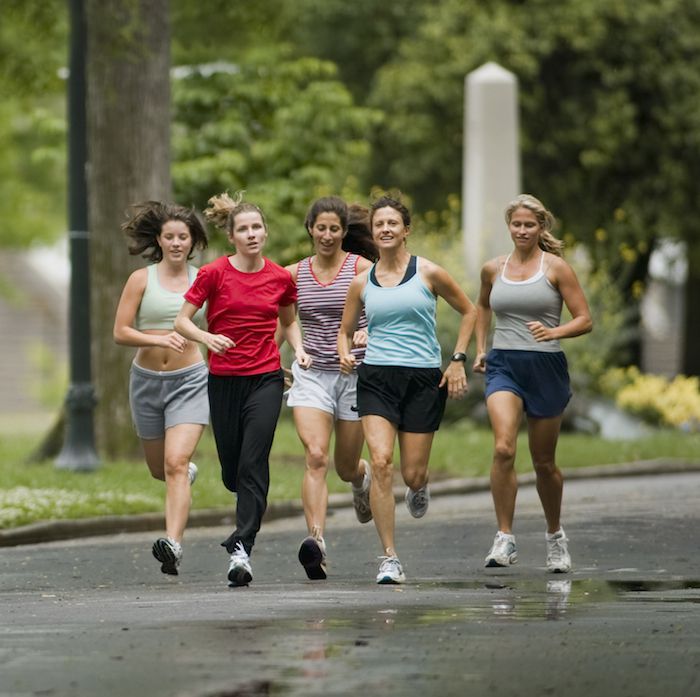 A group of Women are running happily on running track wearing colorful running kit while wearing shoe with shoelace