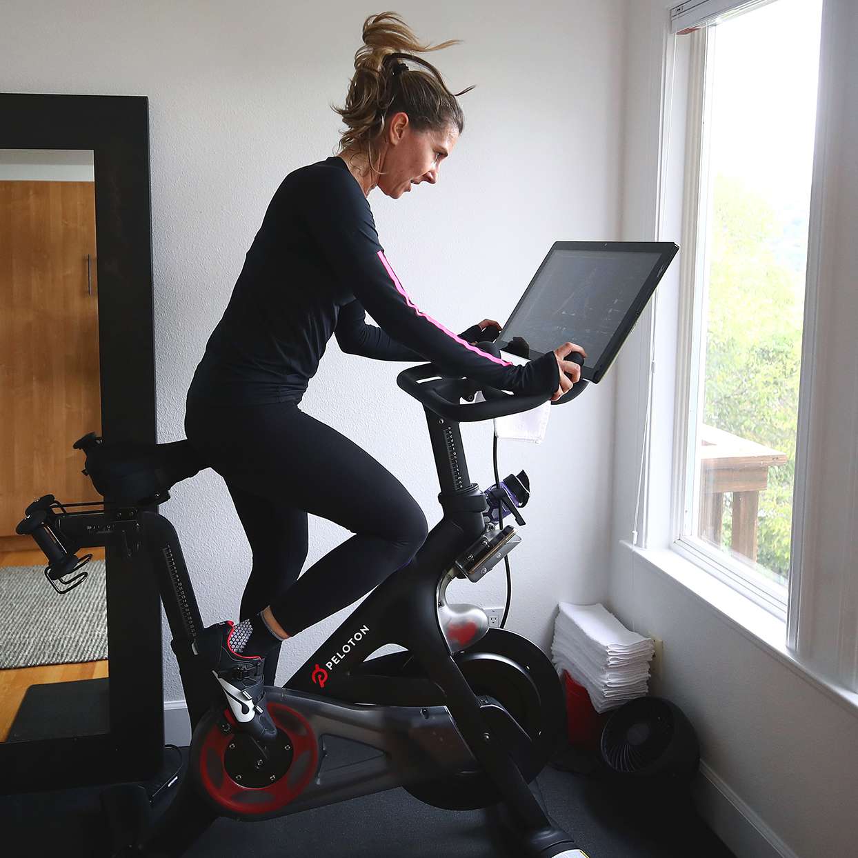 woman using a pelon bike and a peloton workout plan
