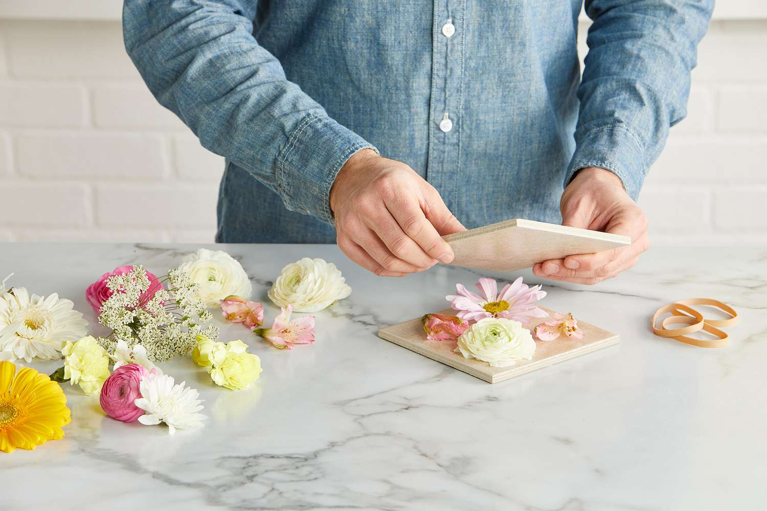 pressing flowers with tiles squares next to rubber band