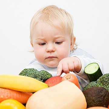 baby looking at vegetables