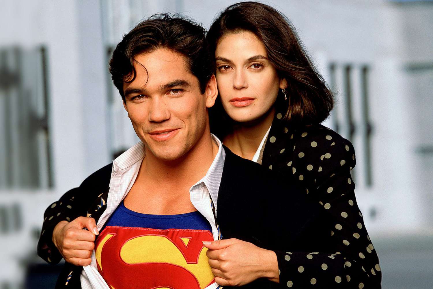 Dean Cain as Superman with Lois Lane pulling open his shirt to reveal the "S" logo.